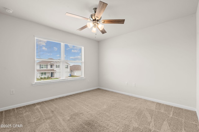 spare room featuring carpet floors, a ceiling fan, and baseboards