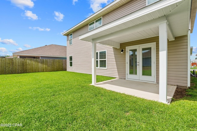 back of house featuring a lawn, a patio area, fence, and french doors