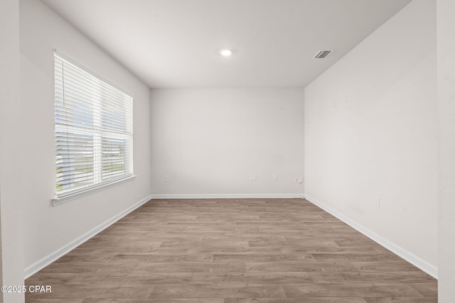 empty room featuring recessed lighting, baseboards, visible vents, and wood finished floors