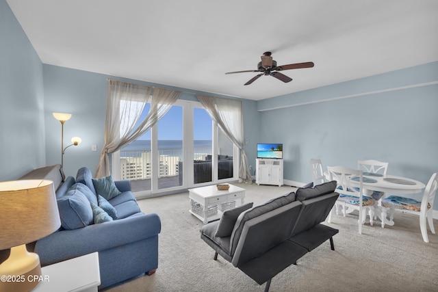 carpeted living area with a ceiling fan