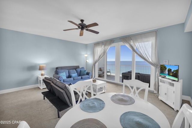 dining room featuring ceiling fan, baseboards, and light colored carpet