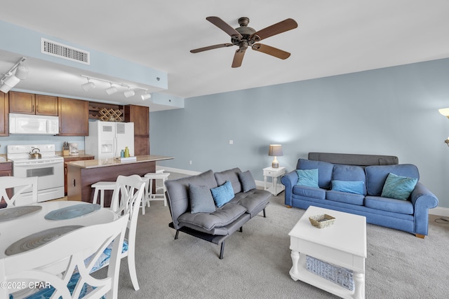 living area with track lighting, visible vents, a ceiling fan, baseboards, and light colored carpet