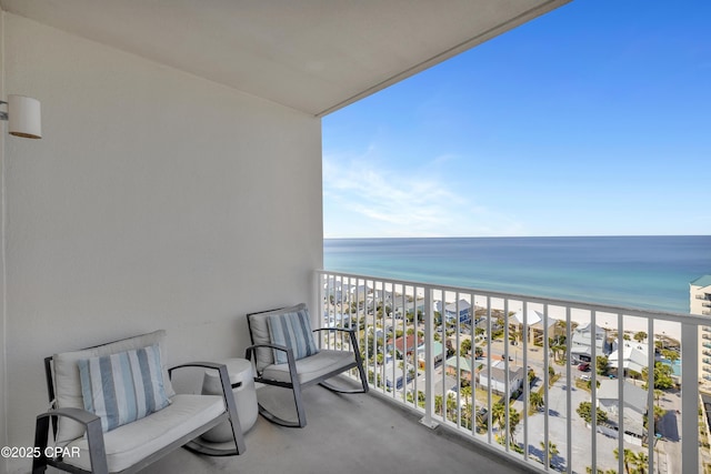 balcony featuring a view of the beach and a water view