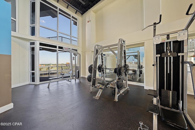 workout area with a towering ceiling and baseboards