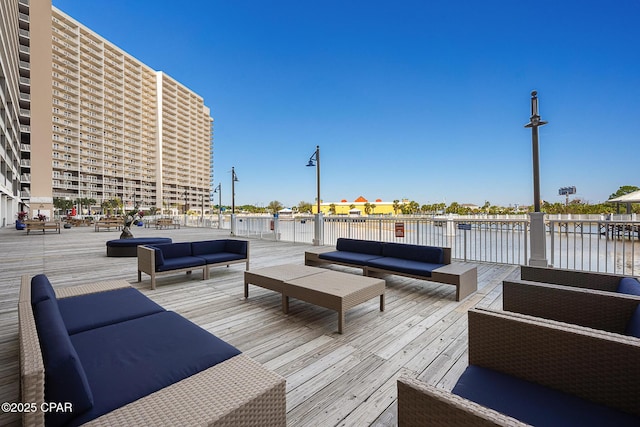 wooden terrace featuring outdoor lounge area and a water view