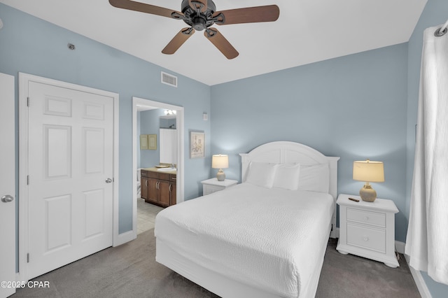 carpeted bedroom with baseboards, visible vents, connected bathroom, and ceiling fan
