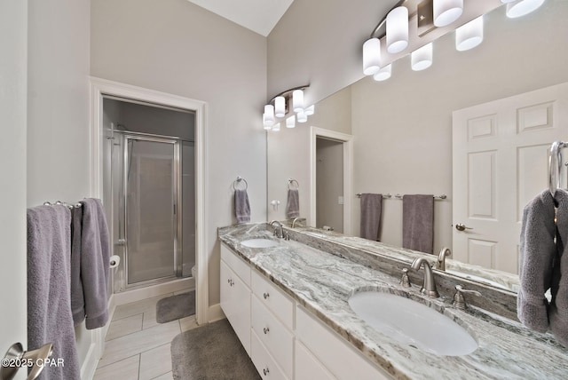 bathroom featuring a shower stall, double vanity, and a sink