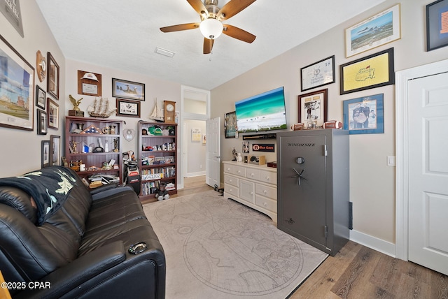 living room with wood finished floors, ceiling fan, and baseboards