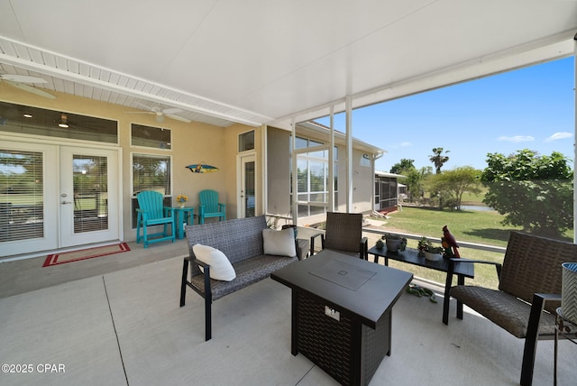 view of patio / terrace with a ceiling fan, french doors, an outdoor living space, and a sunroom
