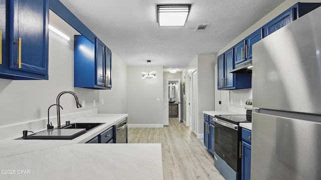 kitchen featuring light countertops, appliances with stainless steel finishes, blue cabinets, and a sink