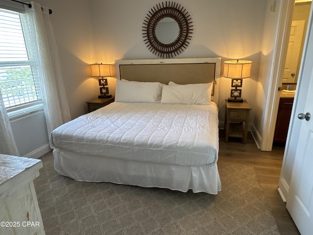 bedroom featuring wood finished floors and baseboards