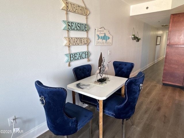 dining room featuring wood finished floors and baseboards