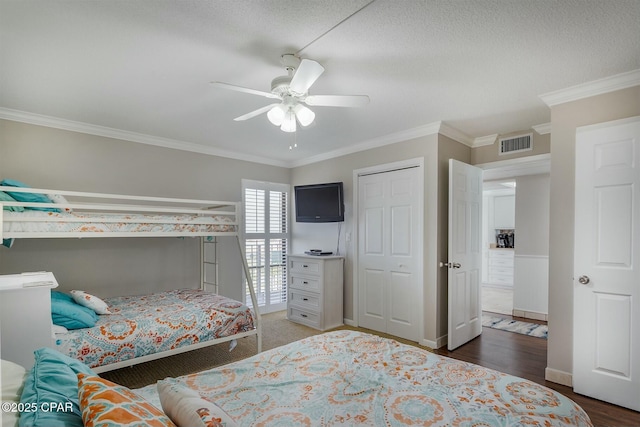 11619 Front Bch Unit 610, Panama City Beach, FL 32407 - bedroom with crown molding, ceiling fan, wood finished floors, a closet, and a textured ceiling