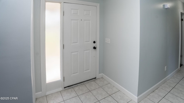 entryway with baseboards and light tile patterned flooring