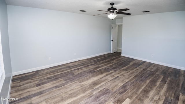spare room with ceiling fan, baseboards, visible vents, and dark wood-style floors