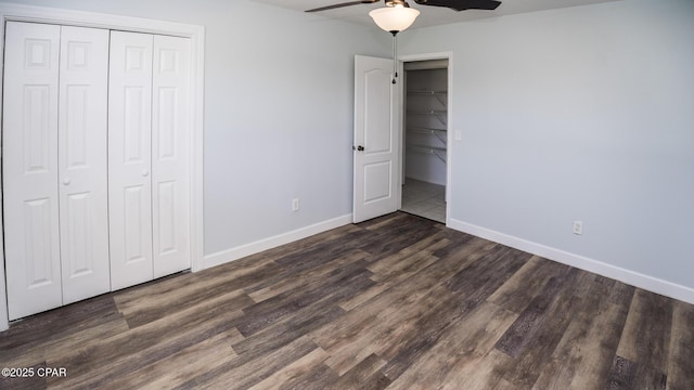 unfurnished bedroom featuring baseboards, a ceiling fan, wood finished floors, and a closet