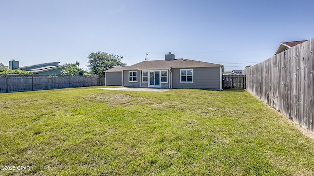rear view of house featuring a lawn, a patio area, and a fenced backyard