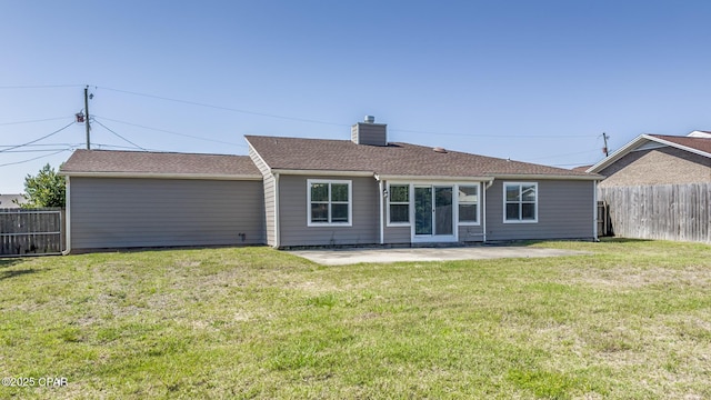 rear view of house featuring a chimney, fence, a patio, and a lawn