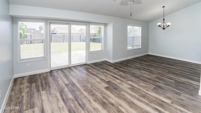 unfurnished dining area with vaulted ceiling, baseboards, dark wood-style flooring, and ceiling fan with notable chandelier