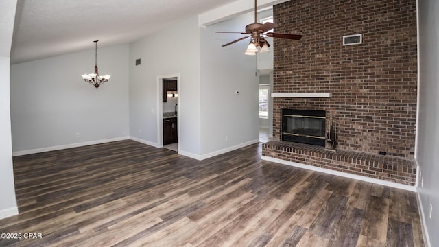 unfurnished living room with high vaulted ceiling, ceiling fan with notable chandelier, baseboards, a brick fireplace, and dark wood-style floors