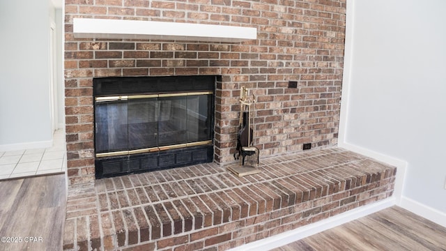 details featuring wood finished floors, baseboards, and a fireplace