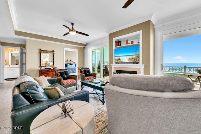 7505 Thomas Dr Unit 512B, Panama City, FL 32408 - living area with a ceiling fan, ornamental molding, a fireplace, and a water view