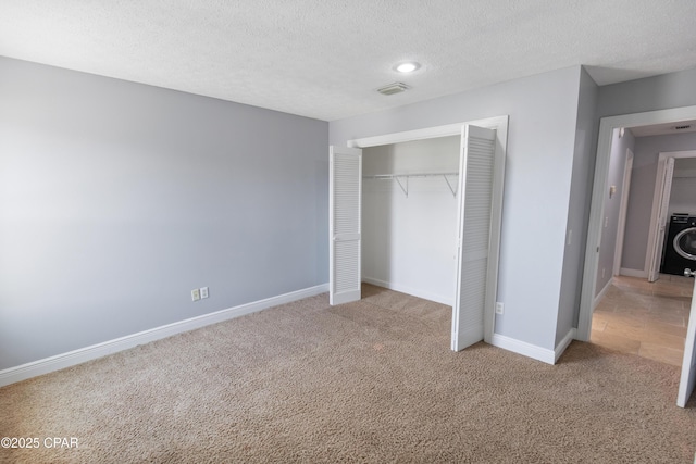 unfurnished bedroom with carpet flooring, a textured ceiling, baseboards, visible vents, and a closet