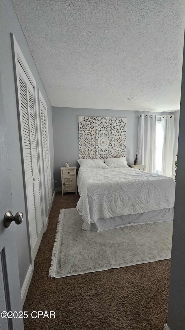 carpeted bedroom with multiple closets, baseboards, and a textured ceiling
