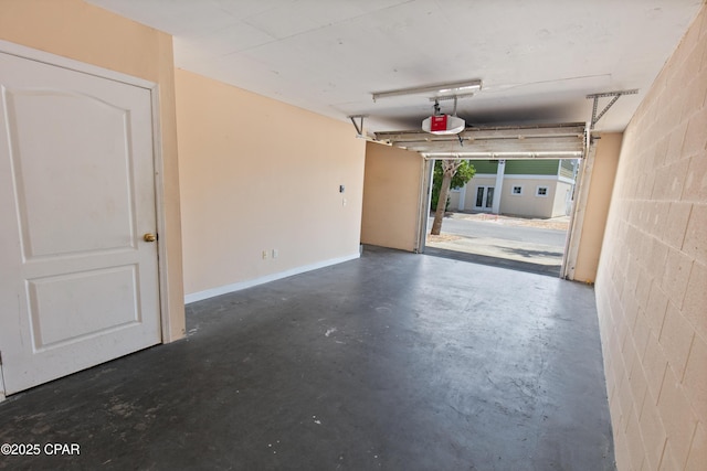 garage with concrete block wall and a garage door opener