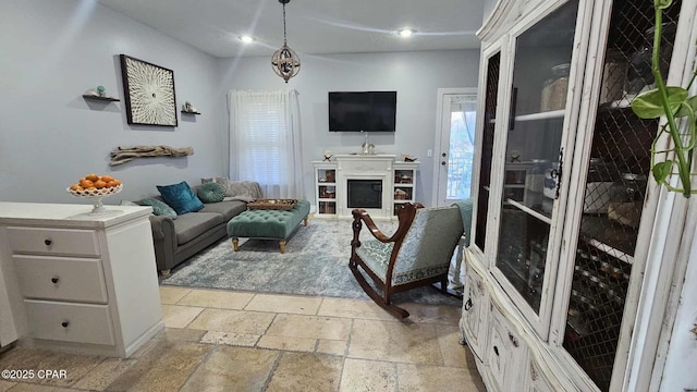 living room with a fireplace, stone tile flooring, and recessed lighting