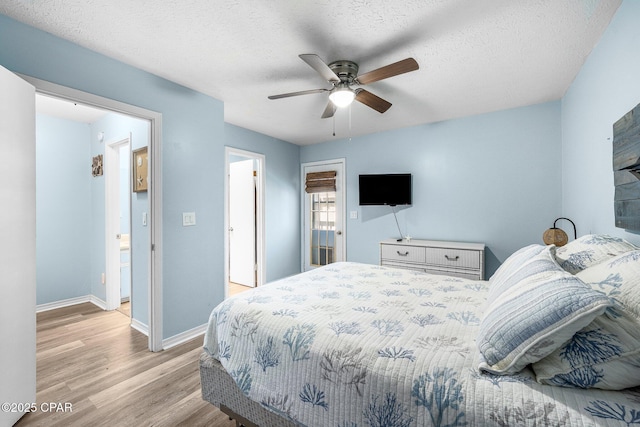 171 Damon Cir, Panama City Beach, FL 32407 - bedroom with light wood finished floors, baseboards, a ceiling fan, and a textured ceiling