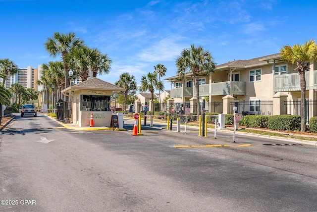171 Damon Cir, Panama City Beach, FL 32407 - view of asphalt street featuring a gated entry, street lights, traffic signs, and curbs