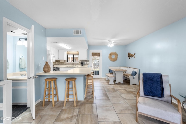 171 Damon Cir, Panama City Beach, FL 32407 - kitchen with a sink, freestanding refrigerator, ceiling fan, white cabinets, and light countertops