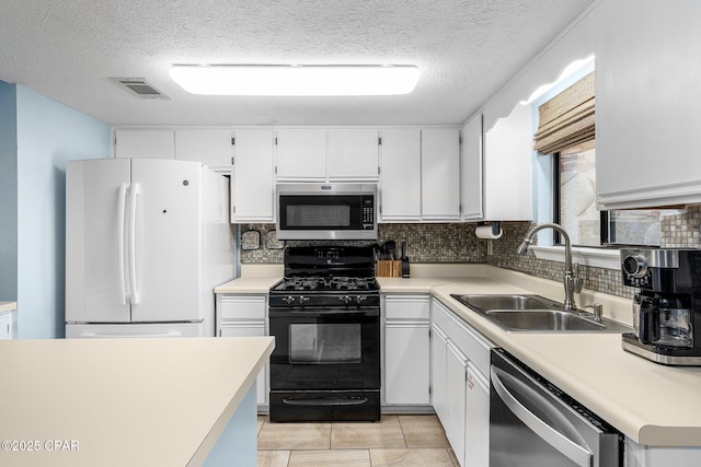 171 Damon Cir, Panama City Beach, FL 32407 - kitchen with stainless steel appliances, a sink, tasteful backsplash, white cabinets, and a textured ceiling