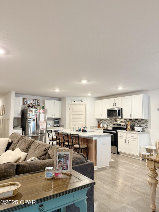 living area with light wood-type flooring and recessed lighting