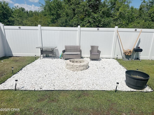 view of patio featuring fence and a fire pit