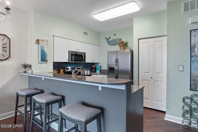 9900 S Thomas Dr Unit 819, Panama City Beach, FL 32408 - kitchen with visible vents, baseboards, white cabinets, and stainless steel appliances