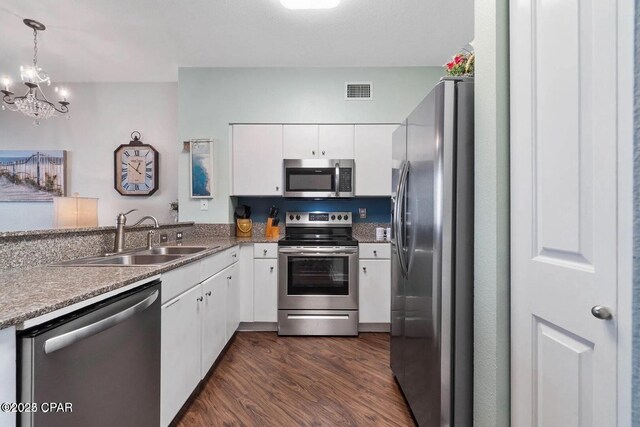 9900 S Thomas Dr Unit 819, Panama City Beach, FL 32408 - kitchen with an inviting chandelier, dark wood-style floors, white cabinetry, a sink, and stainless steel appliances