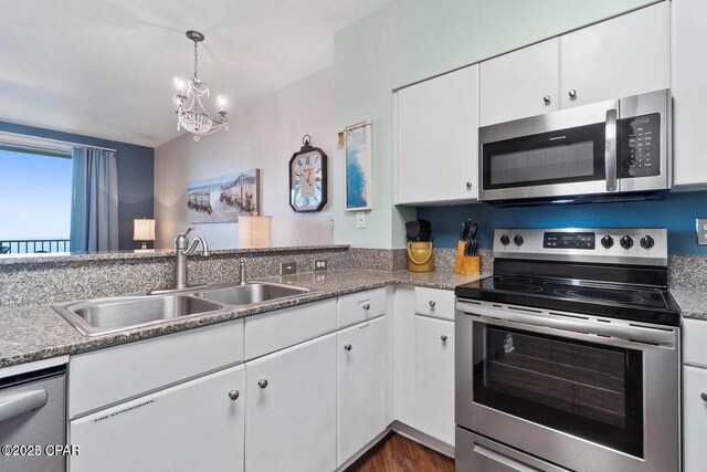 9900 S Thomas Dr Unit 819, Panama City Beach, FL 32408 - kitchen featuring white cabinets, a notable chandelier, a sink, stainless steel appliances, and decorative light fixtures