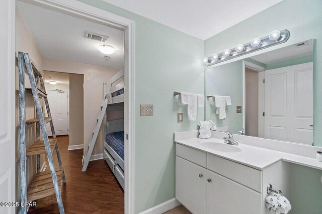 9900 S Thomas Dr Unit 819, Panama City Beach, FL 32408 - bathroom featuring visible vents, baseboards, wood finished floors, and vanity