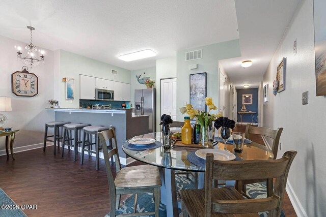 9900 S Thomas Dr Unit 819, Panama City Beach, FL 32408 - dining space with baseboards, a notable chandelier, dark wood-style floors, and visible vents