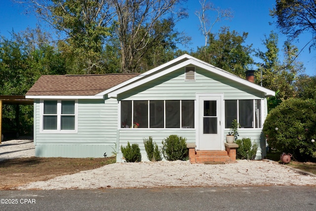 manufactured / mobile home featuring a sunroom and roof with shingles