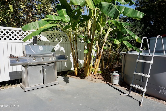 view of patio / terrace featuring fence and a grill