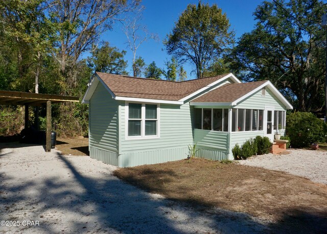 view of front of house featuring a sunroom and roof with shingles
