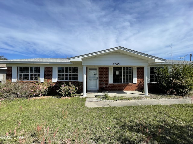 ranch-style house with a front yard and brick siding