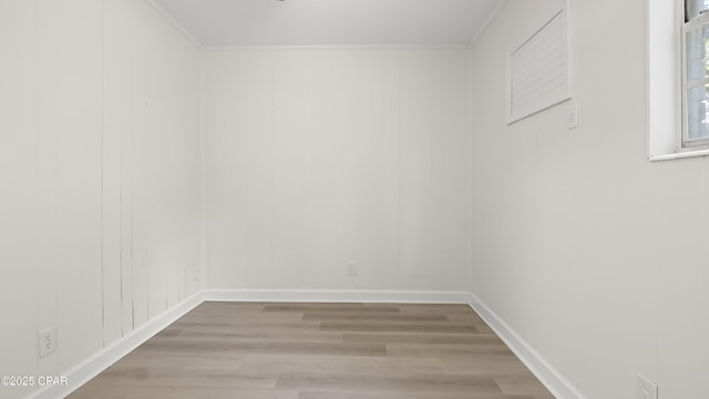unfurnished room featuring baseboards, wood finished floors, and ornamental molding