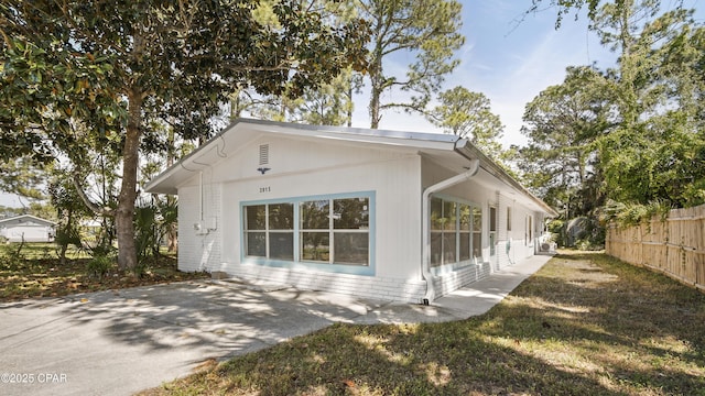 view of property exterior with fence and a patio area
