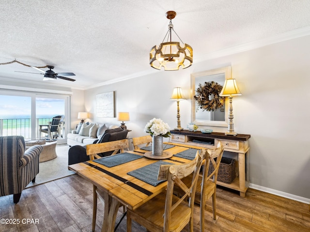 5801 Thomas Dr Unit 415, Panama City, FL 32408 - dining space featuring ceiling fan with notable chandelier, ornamental molding, a textured ceiling, and hardwood / wood-style floors