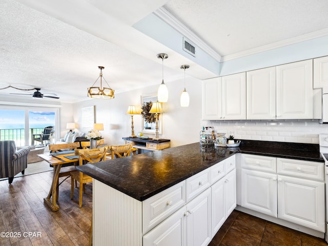 5801 Thomas Dr Unit 415, Panama City, FL 32408 - kitchen featuring white cabinets, a peninsula, tasteful backsplash, and crown molding