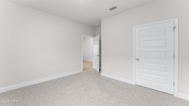 unfurnished bedroom with visible vents, carpet, and baseboards
